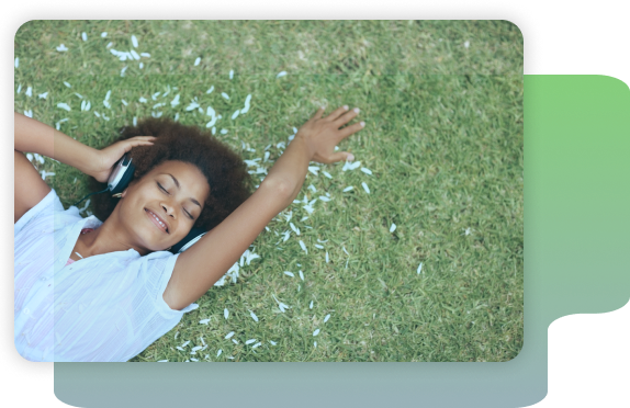 Person laying in grass with headphones on